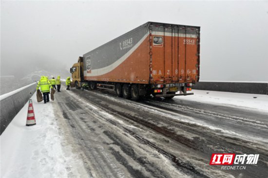 <em>货车</em>“雪中”受阻 高速管理所用麻袋铺路200米助其脱困